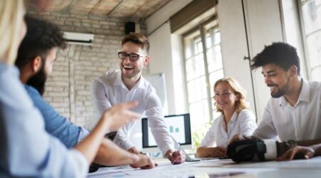schwerpunkt-digital-marketing Junges, froehliches Team bei Besprechung in Unternehmen.